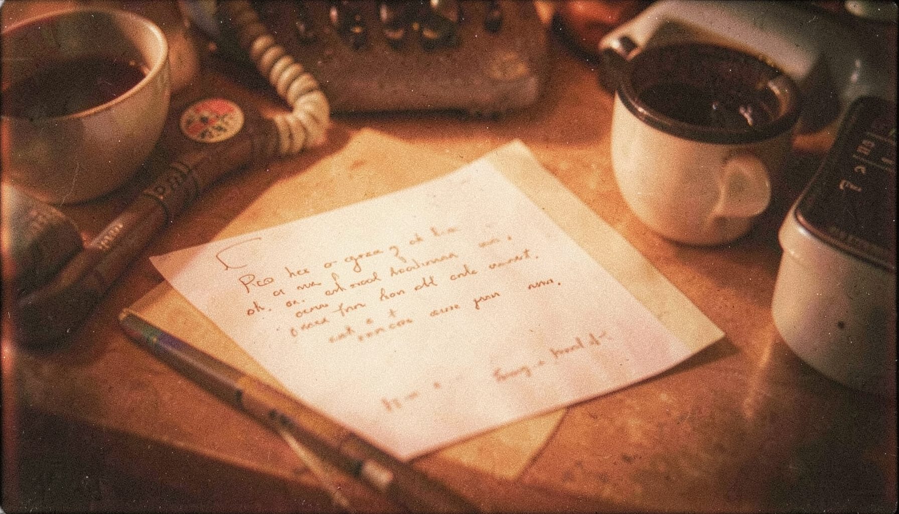 Warm-toned analog film photograph with visible grain showing a softly lit desk with a handwritten note, a telephone, and a coffee cup, evoking a personal and welcoming atmosphere in earthy browns and creams.